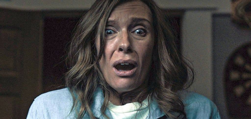 A still from Hereditary of actress Toni Collette looking on in horror