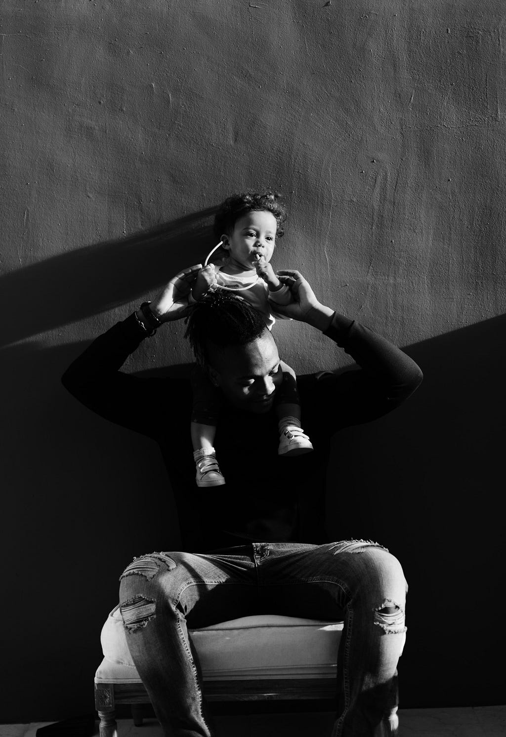 Black and white photo of a father holding young child.