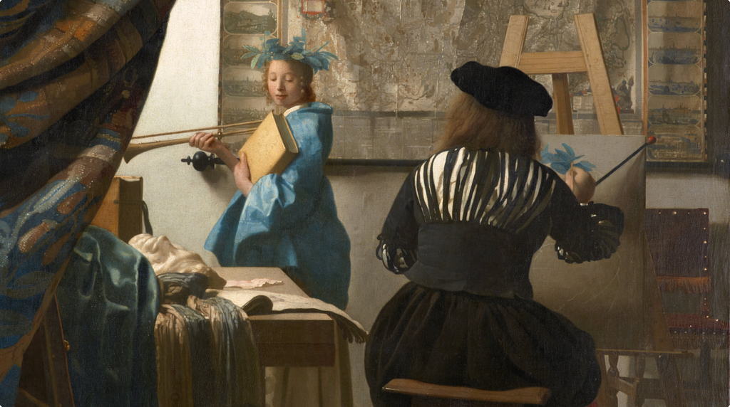 Oil painting of an artist seen from behind, seated at an easel and painting a young woman in a blue dress who poses as a muse holding a trumpet and book. The studio is filled with maps, drapes and props. The painter’s brush is raised mid-stroke, caught in the act of making.