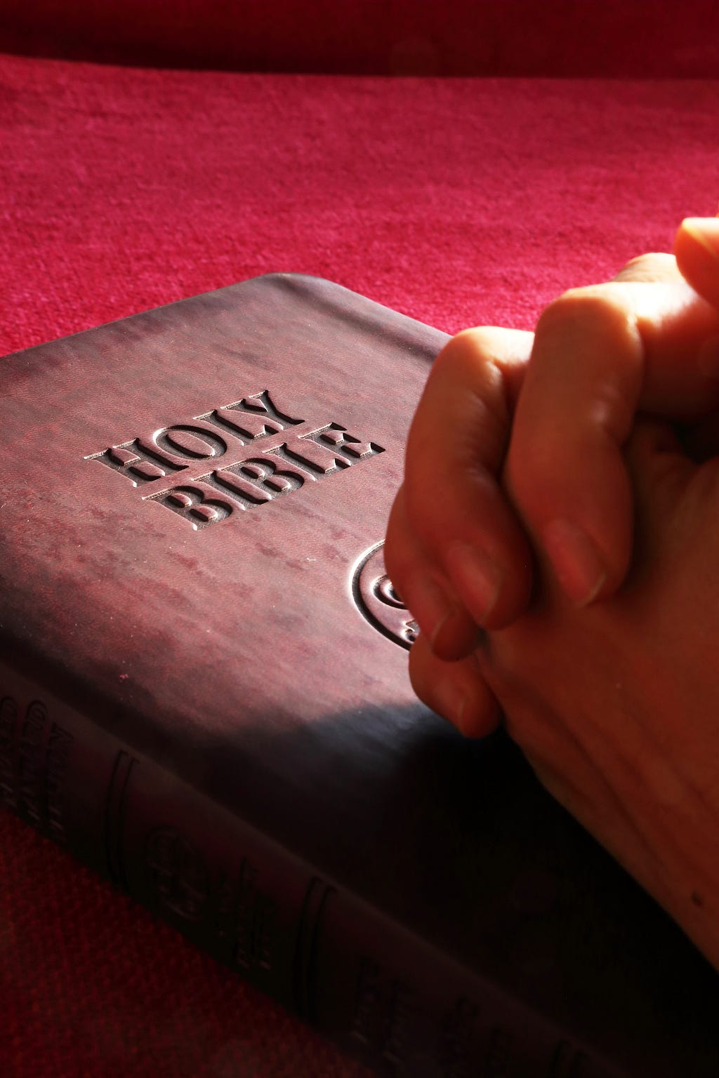 Hands clasped over The Holy Bible, truly powerful!