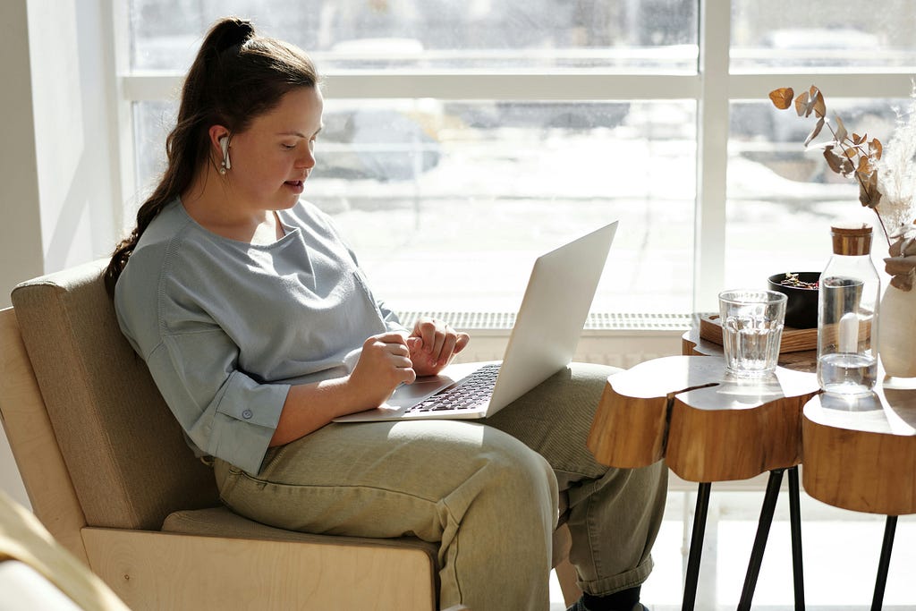 Woman sitting on a sofa while using a laptop.