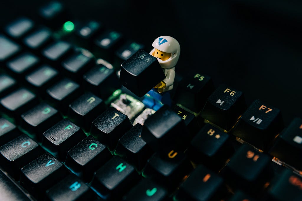 A lego toy holds up a keyboard key.