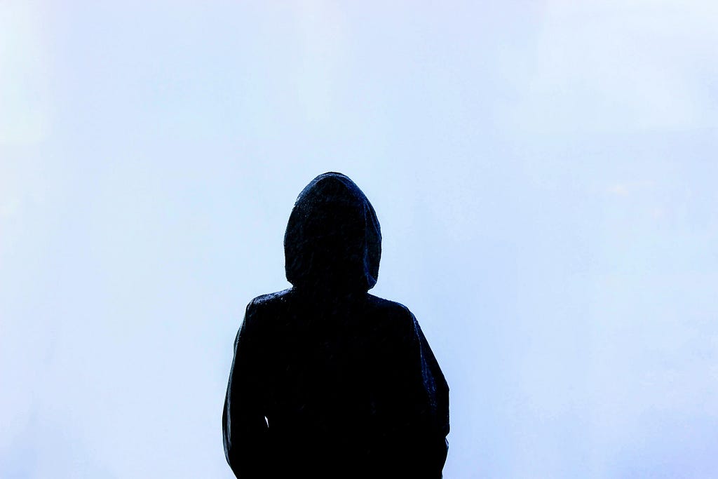Silhouette of a person wearing a hood