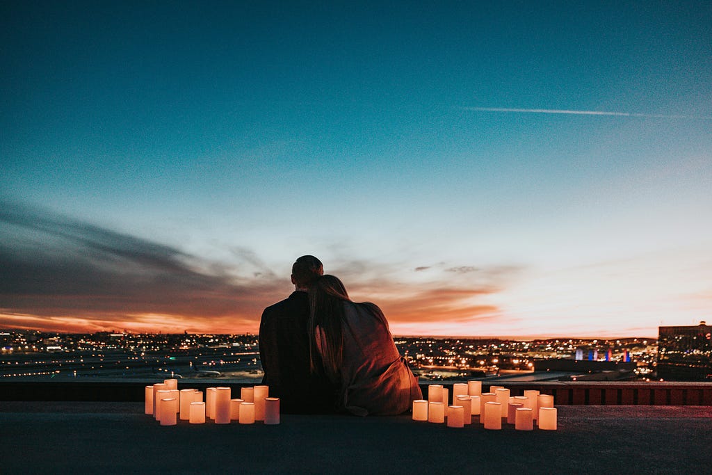 A couple enjoying the city lights at night.