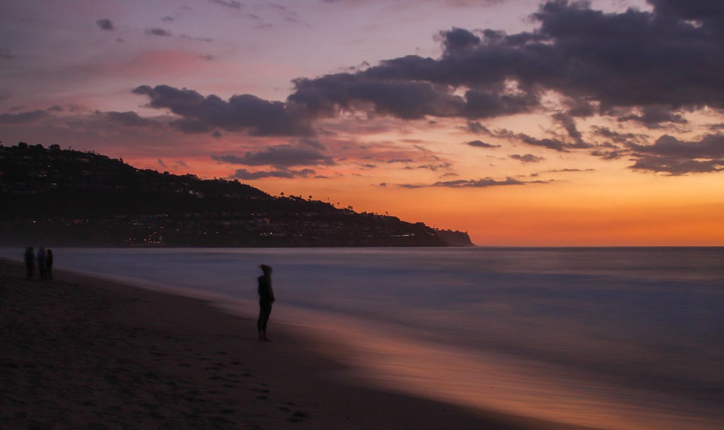 A woman gazes out to sea at sunset in Torrance Beach