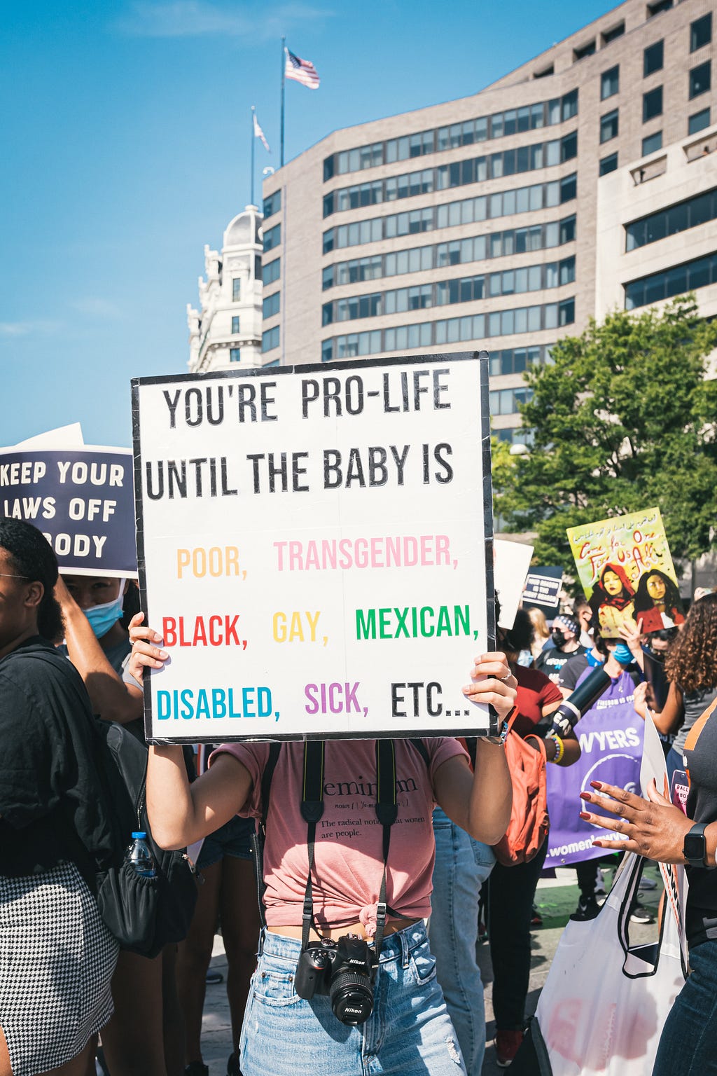 Protest photo sign that says, “You’re pro-life until the baby is poor, transgender, black, gay, Mexican, disabled, sick, etc.”