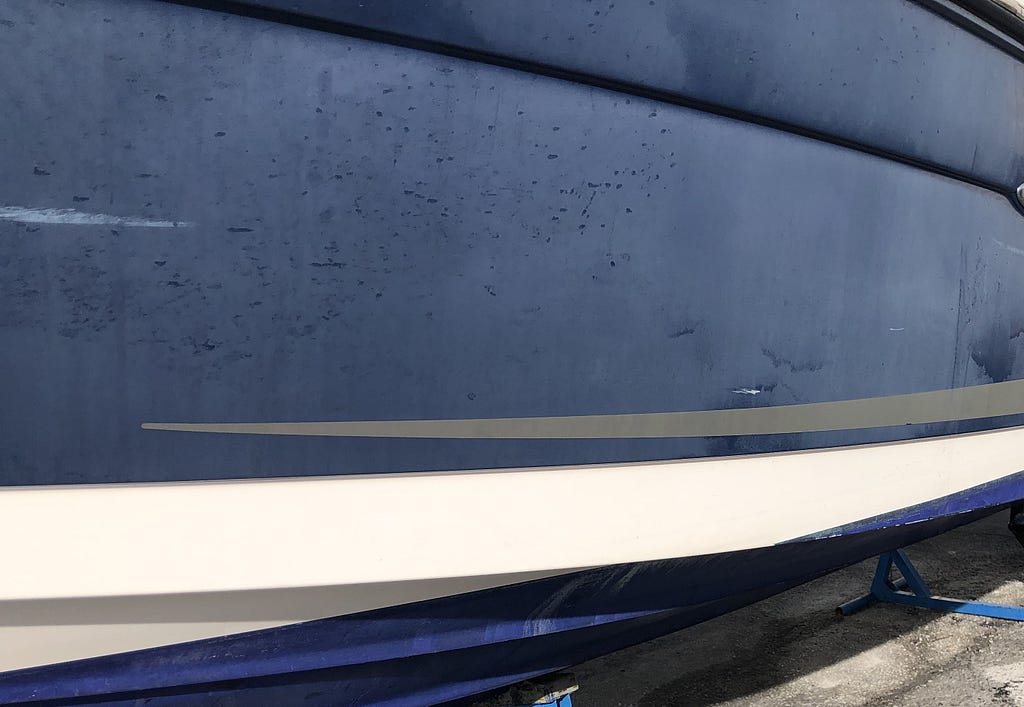 A very sun damaged blue boat hull
