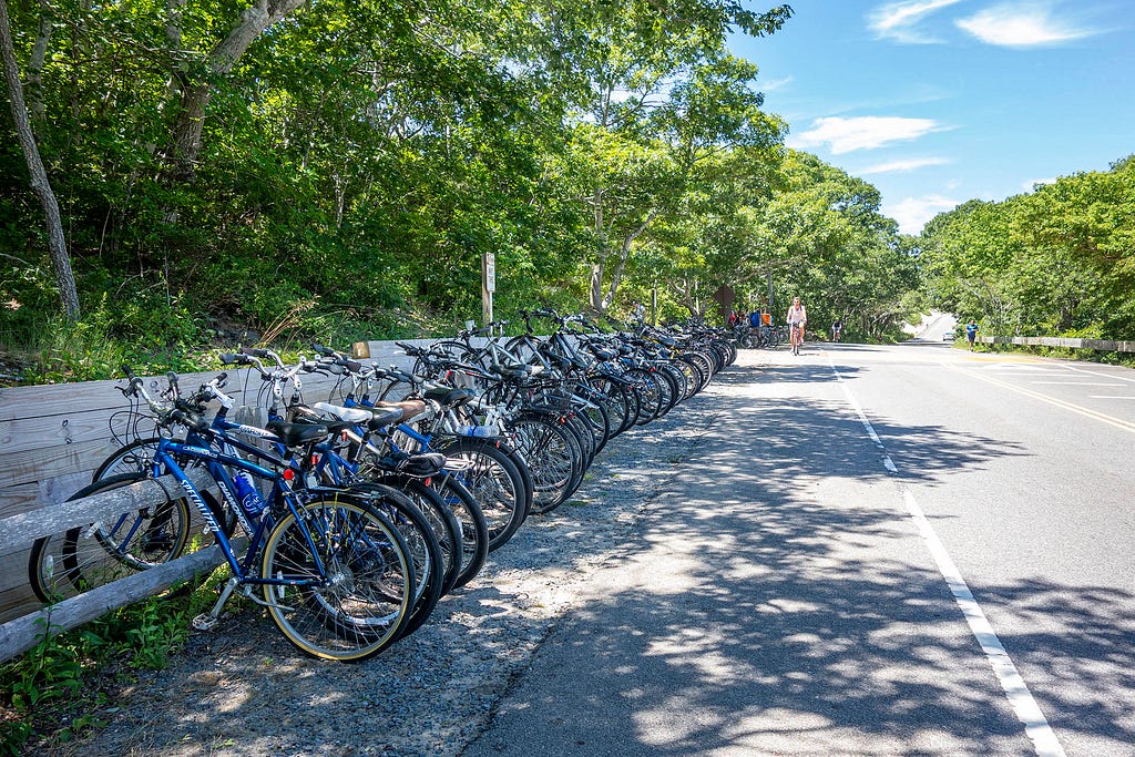 a row of bicycles parked on a roadside fence