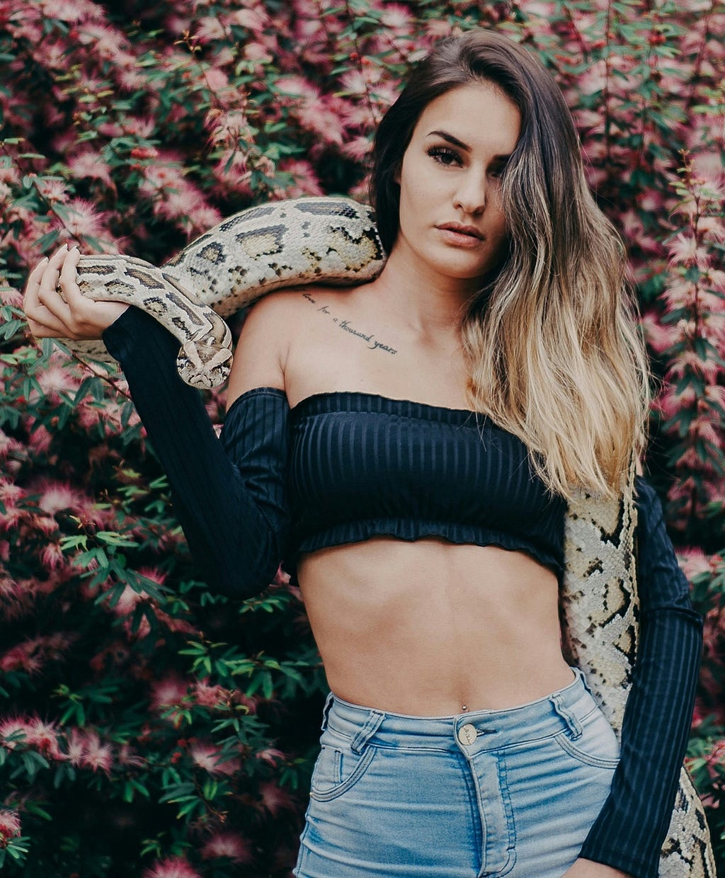 woman with large snake over her shoulders