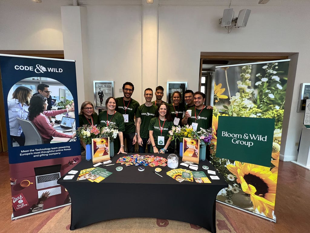 The Bloom & Wild tech team standing behind a sponsors booth at the Brighton Ruby conference 2023