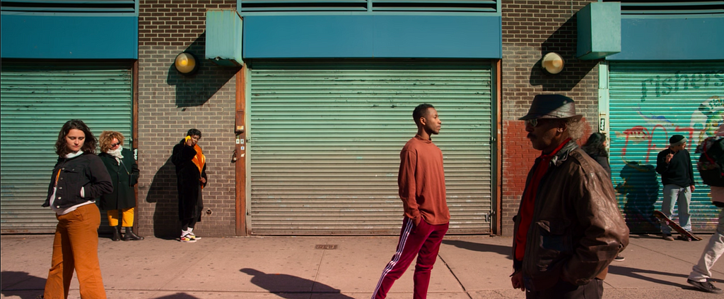 Various individuals standing apart on a street in New York