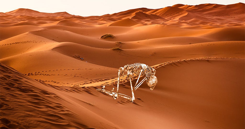 human skeleton crawling through the desert