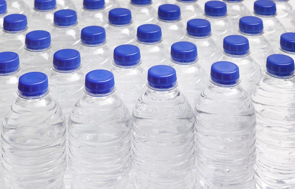 Many bottles of water in plastic containers.
