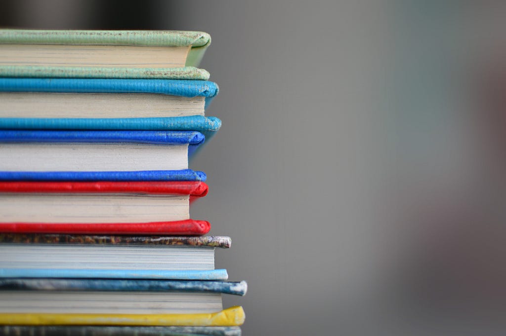 Stock image of the side of a stack of brightly coloured books