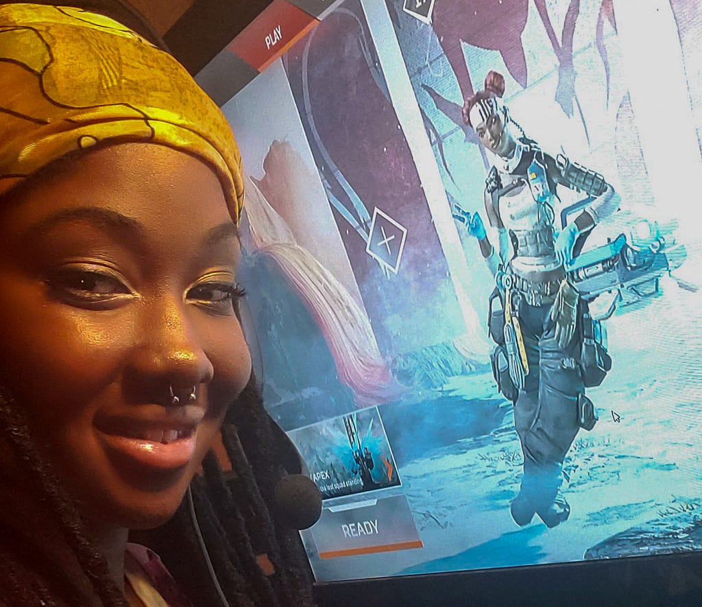 Symone in front of her Game PC with Apex Legends in the background on a computer screen.