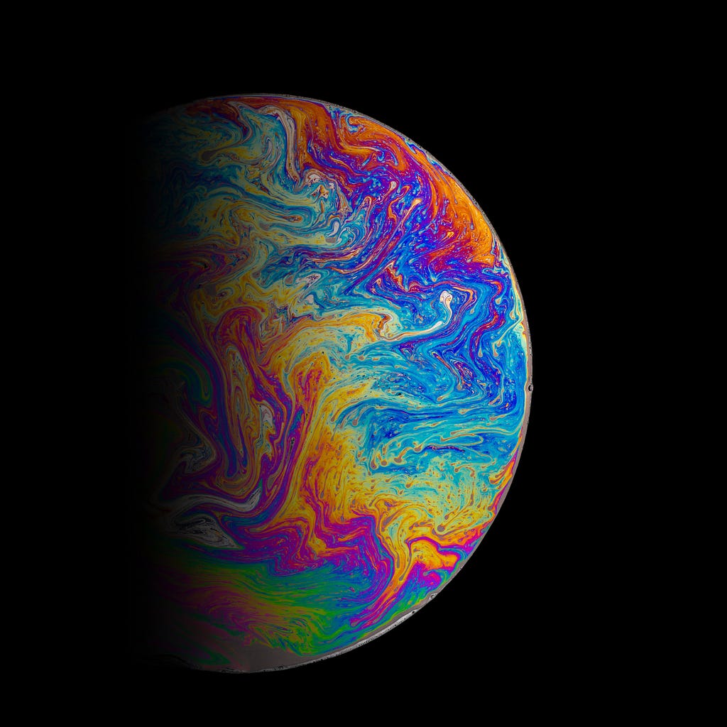 Oil on canvas meant to resemble a brilliantly colored planet — photo courtesy of Daniel Olah and Unsplash.