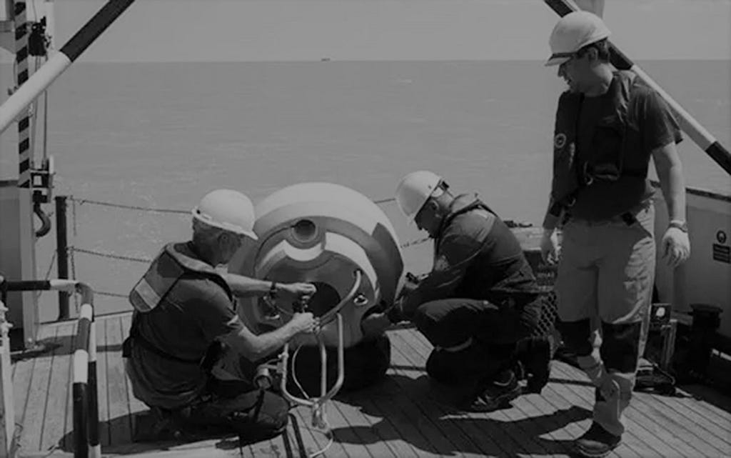 Marine engineers and technicians deploying an ocean data buoy