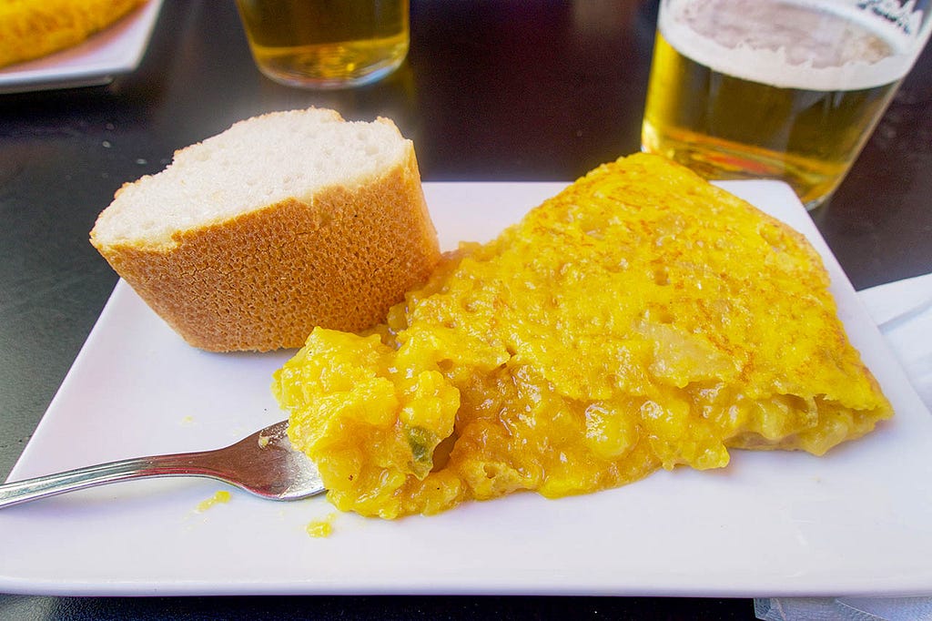 a slice of potato tortilla and a beer