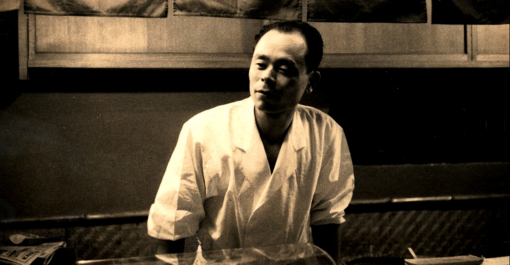 A movie still. Jiro, as a young chef in his kitchen,