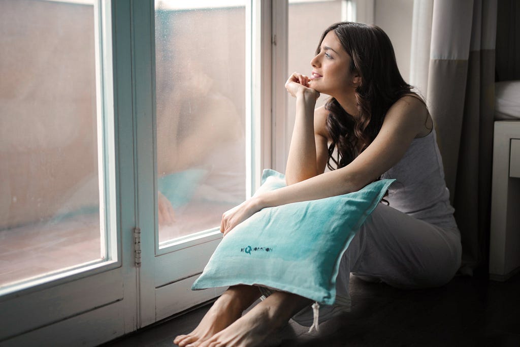 A woman stares out the window with an optimistic look on her face