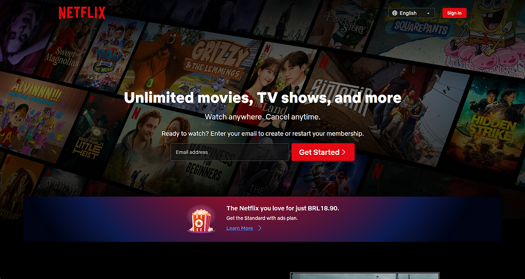 The image shows a screenshot of the Netflix website. The homepage hero section displays “Unlimited movies, TV shows, and more” that are all included in the Entertainment industry. The text below the hero section says “Watch anywhere. Cancel anytime.”