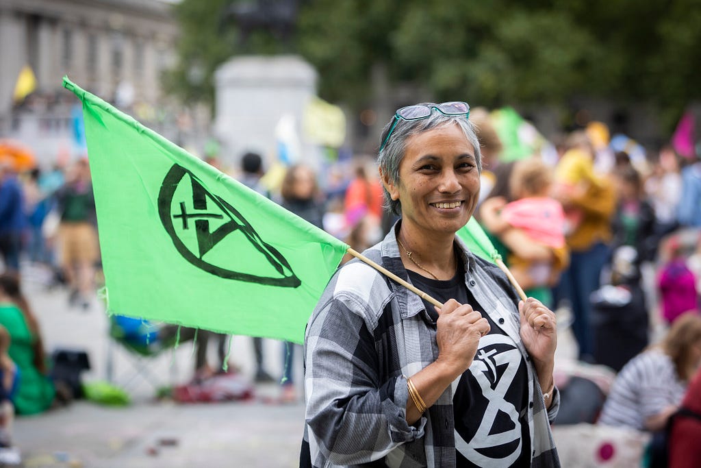 Woman holding a green flag at a crowded outdoor event