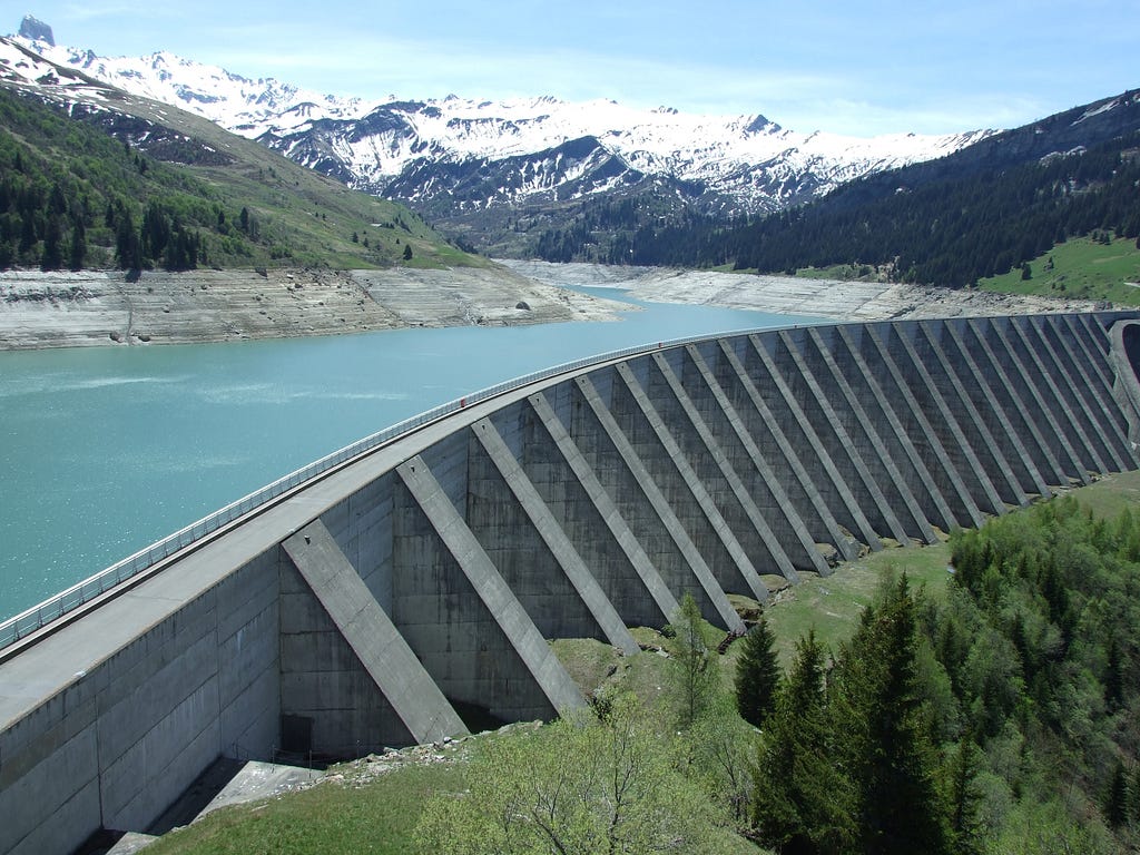 A dam with mountains in the background