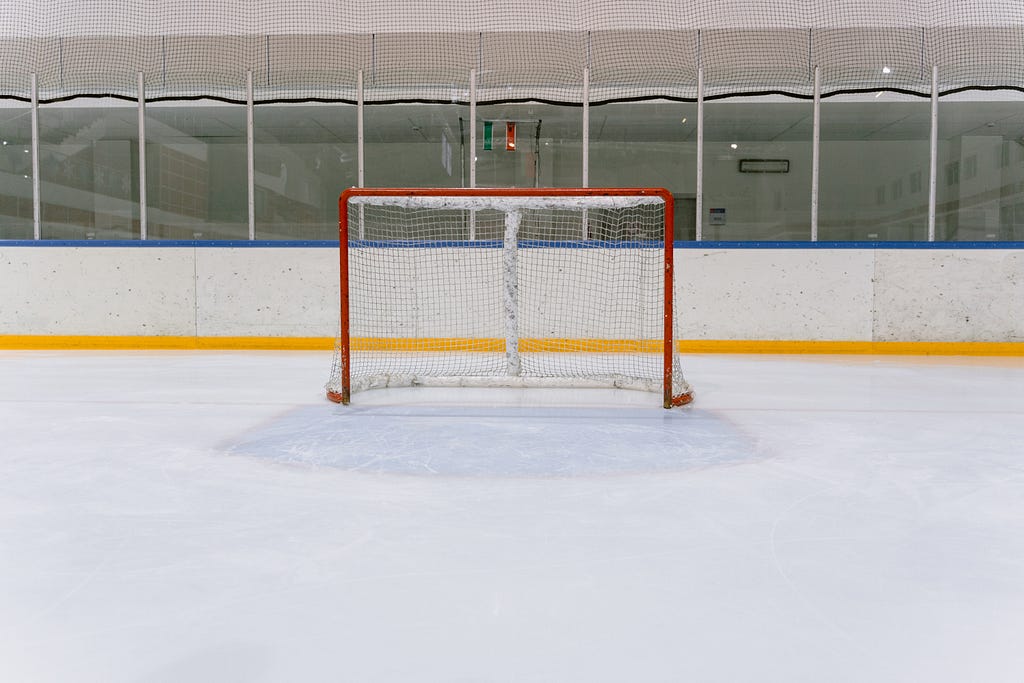 A hockey net on a sheet of ice.