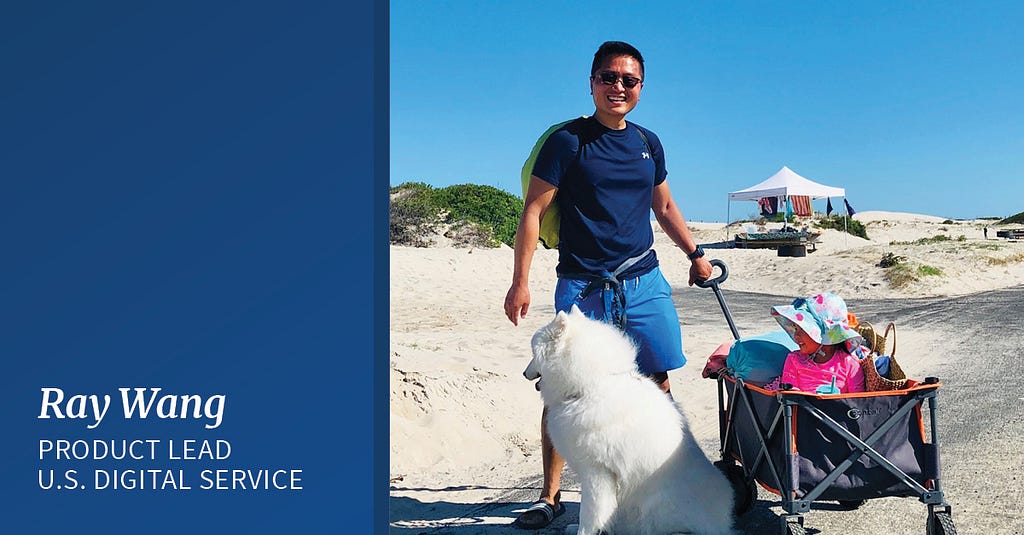 A Chinese American man stands smiling on the beach. He’s wearing sunglasses, a dark blue T-shirt and bright blue pants. There is a large white dog in front of him and his hand rests on a trolley loaded with beach items. To the right white text on a blue background reads “Ray Wang, Product Lead, U.S. Digital Service”