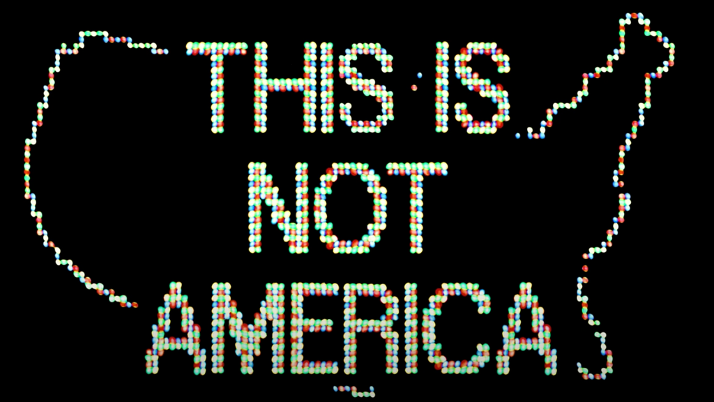 Opening image from the “This is Not America” music video depicts an outline of the United States in colored LED lights with the words “This is Not America” written in all-caps using the same colored LED lights.