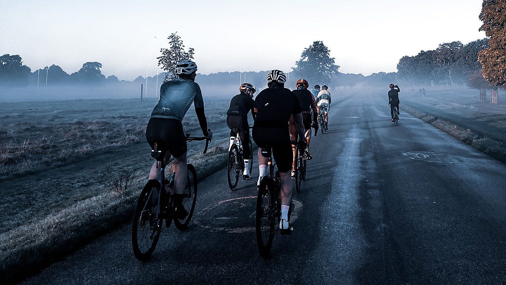 A group of cyclists in a misty park.