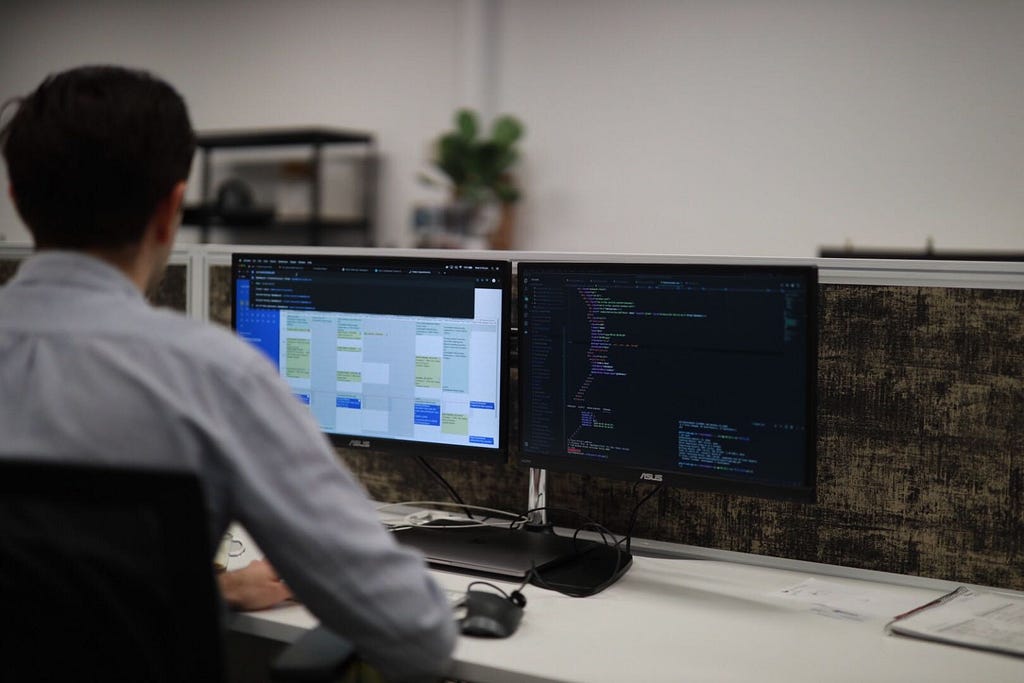 A man on a computer with a calendar and programming