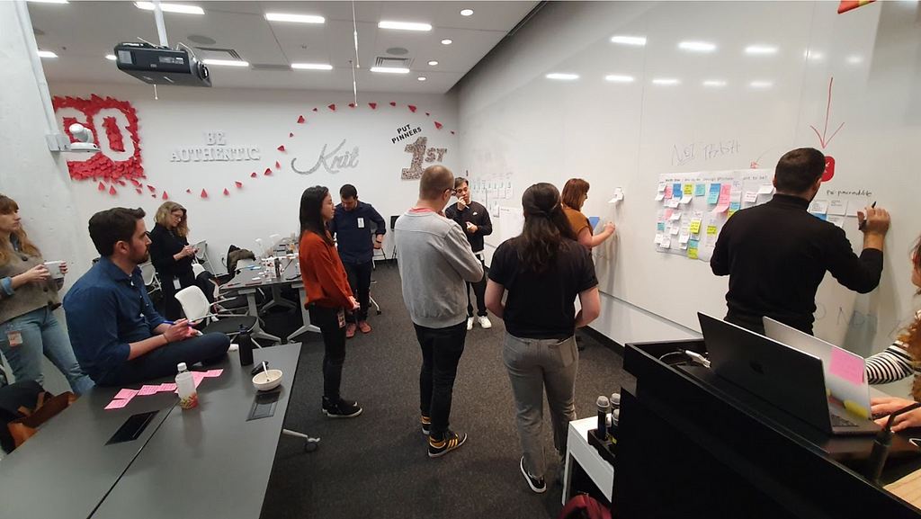 Pinterest Design team members brainstorming together at a white board.