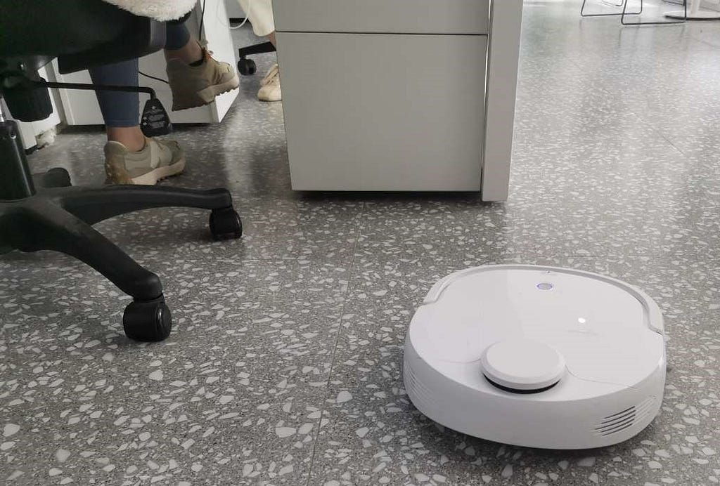My office’s cleaning robot (cutely) cleaning by someone’s feet
