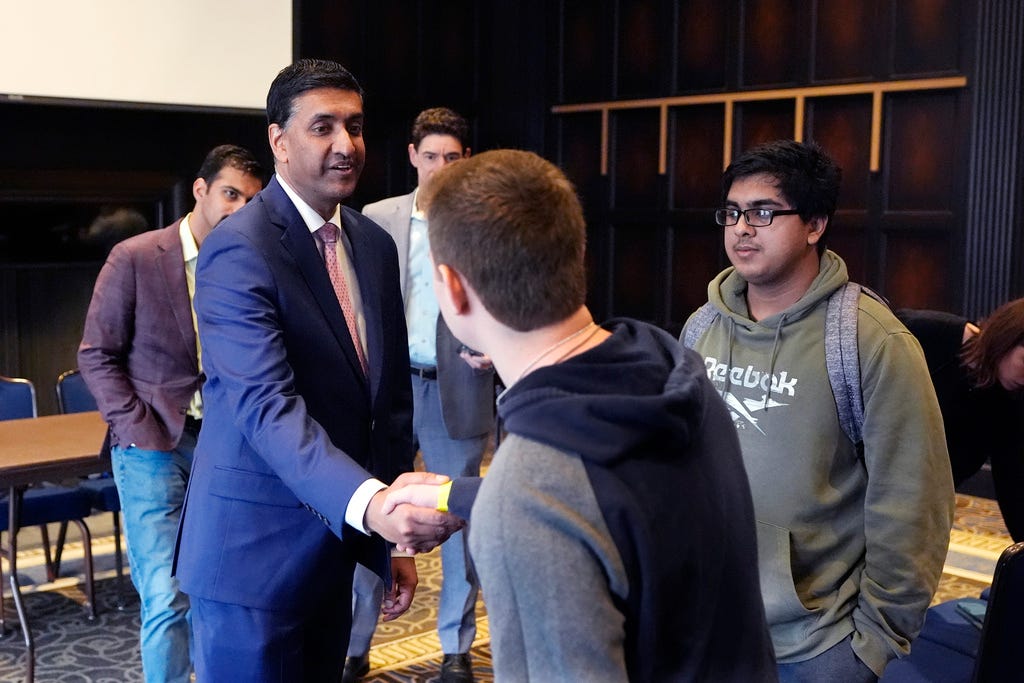 U.S. Rep. Ro Khanna, D-Ca. wears a blue suit while greeting student attendees, two boys in sweatshirts, at an event.