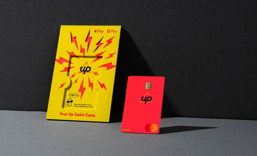 The Up debit card and the packaging it comes in, which is stark yellow and orange.