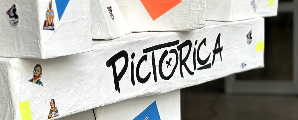 Estructura armada con cajas, diarios y cola vinílica con la palabra “Pictorica” escrita con fibron negro que hace referencia al nombre de la muestra final de la materia Taller 1 de Diseño Multimedial.