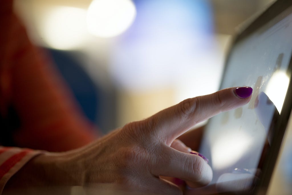 A person clicking the touchscreen of a computer