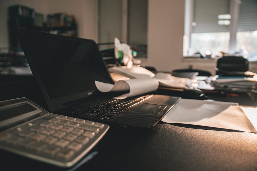 A laptop with a piece of paper on top