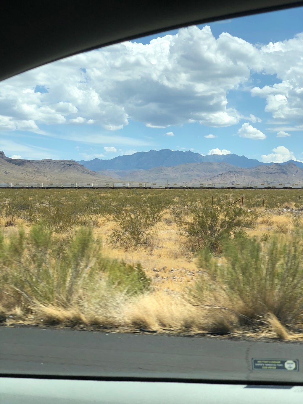 Picture of the Arizona desert and mountains taken through a car window.