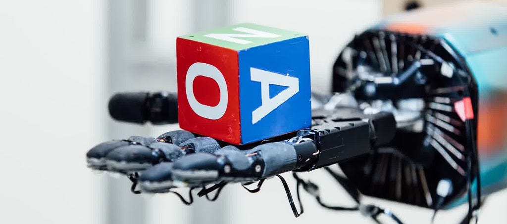 robot hand holding dice with letters on it