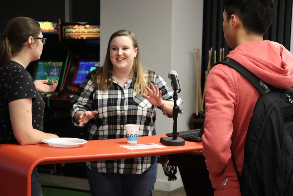 Claire Tolbert conversing with two Meetup attendees in front of a microphone