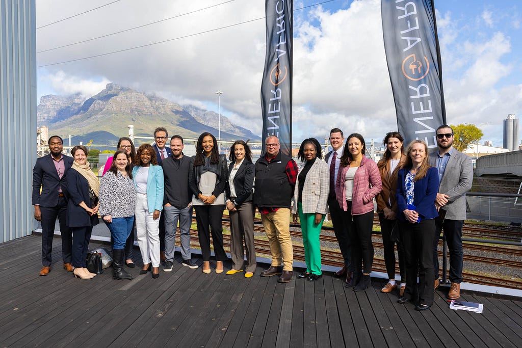 A large group of people posing for a photo with twoEner-G-Africa banners behind them.