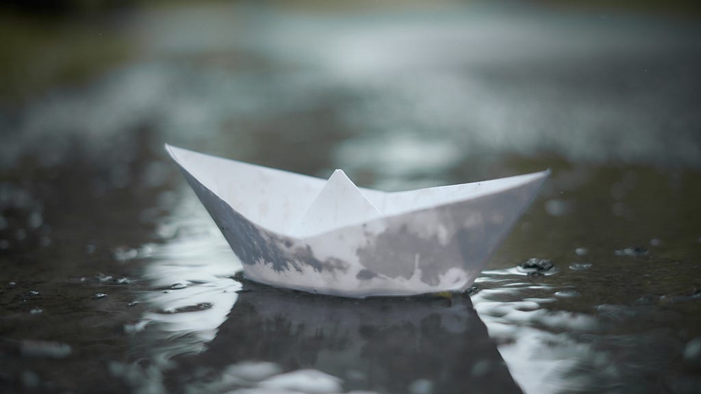 Paper boat in rain.