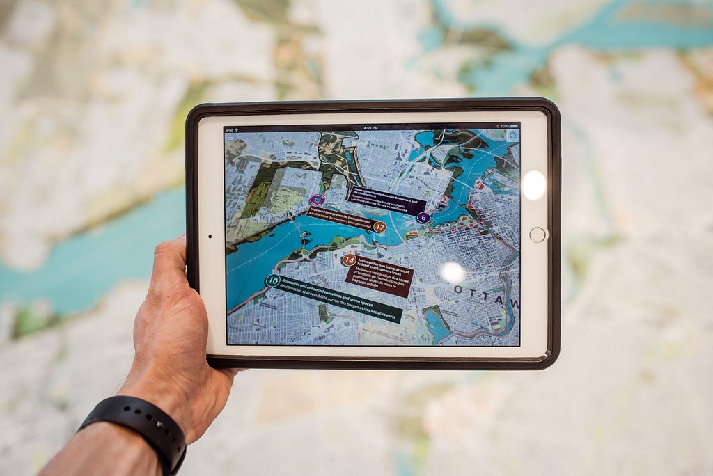 Someone looking at city planning data on a tablet while walking in the street