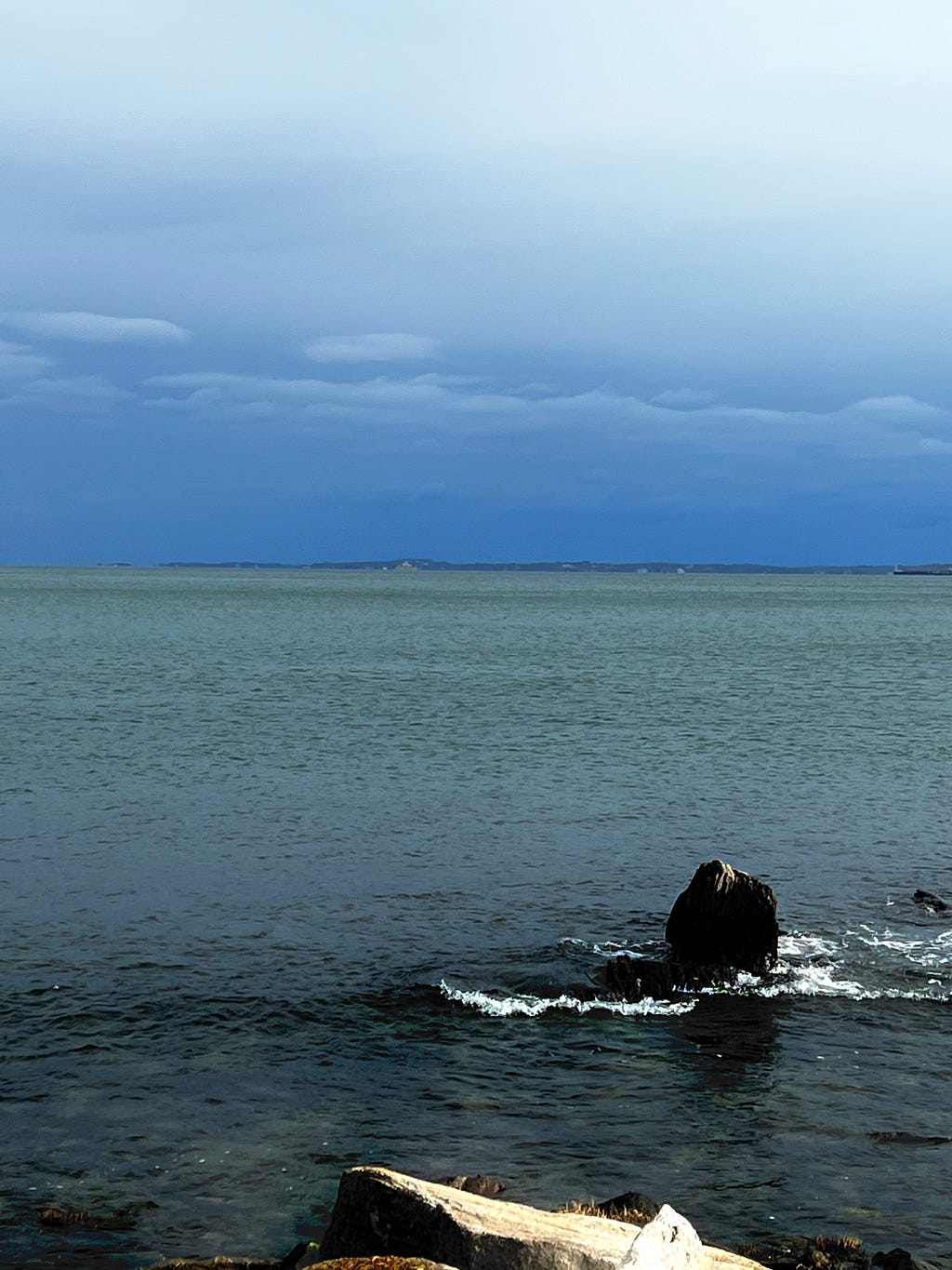 Photo of the waters off Napatree Point, with a dark and stormly sky looming ahead