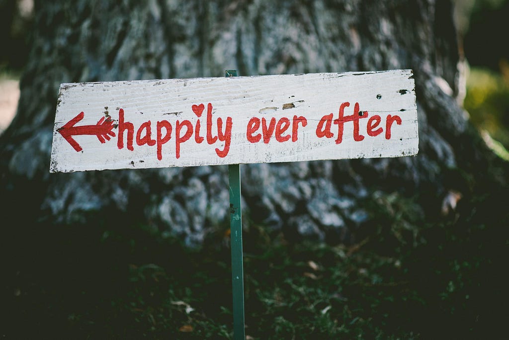 Sign in a forest with “Happily ever after” words