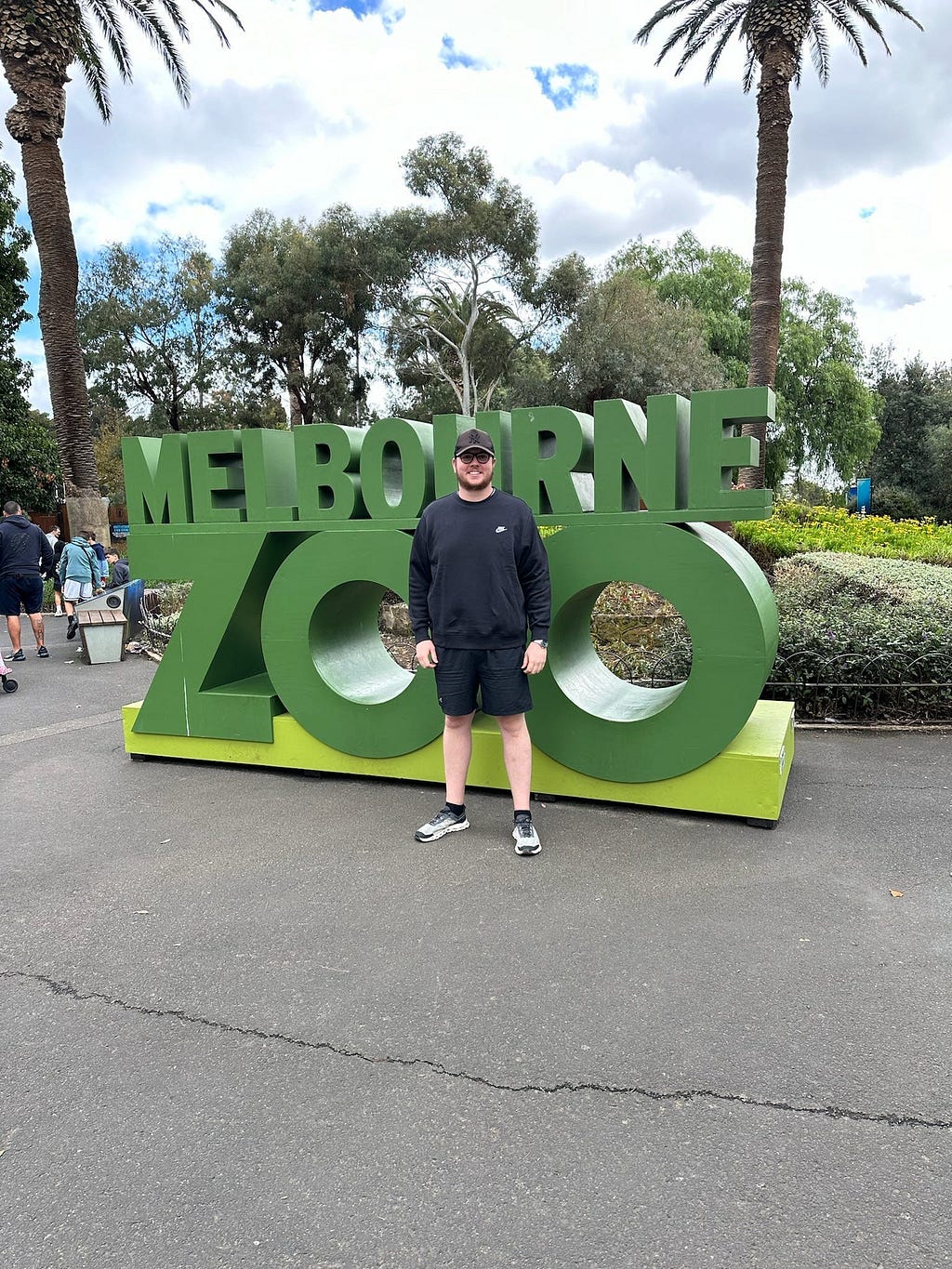 Man standing in front of Melbourne Zoo Sign
