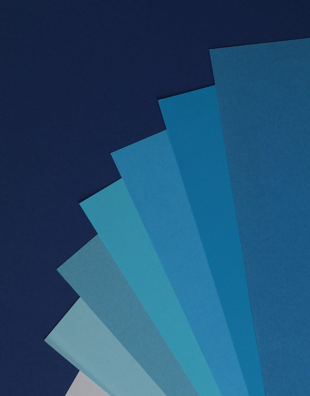 Five sections of different shades of blue on top of a navy background.