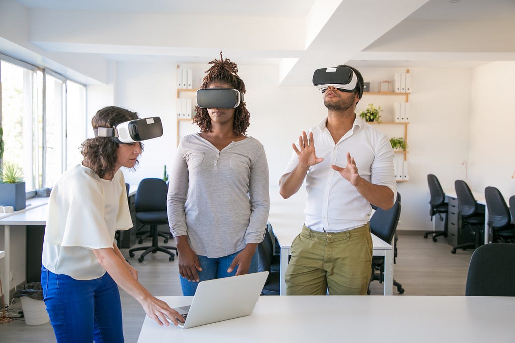 Three people using Virtual Reality holographic headsets, twin technology of Augmented Reality, wich can increase e-commerce sales without the need of such special equipaments.
